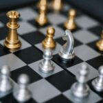 Macro shot of a chessboard featuring gold and silver pieces in strategic play.